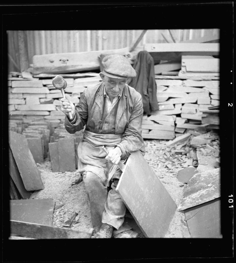 Quarryman splitting a large piece of slate - 'manhollti', Dinorwig Quarry, early 1960s.