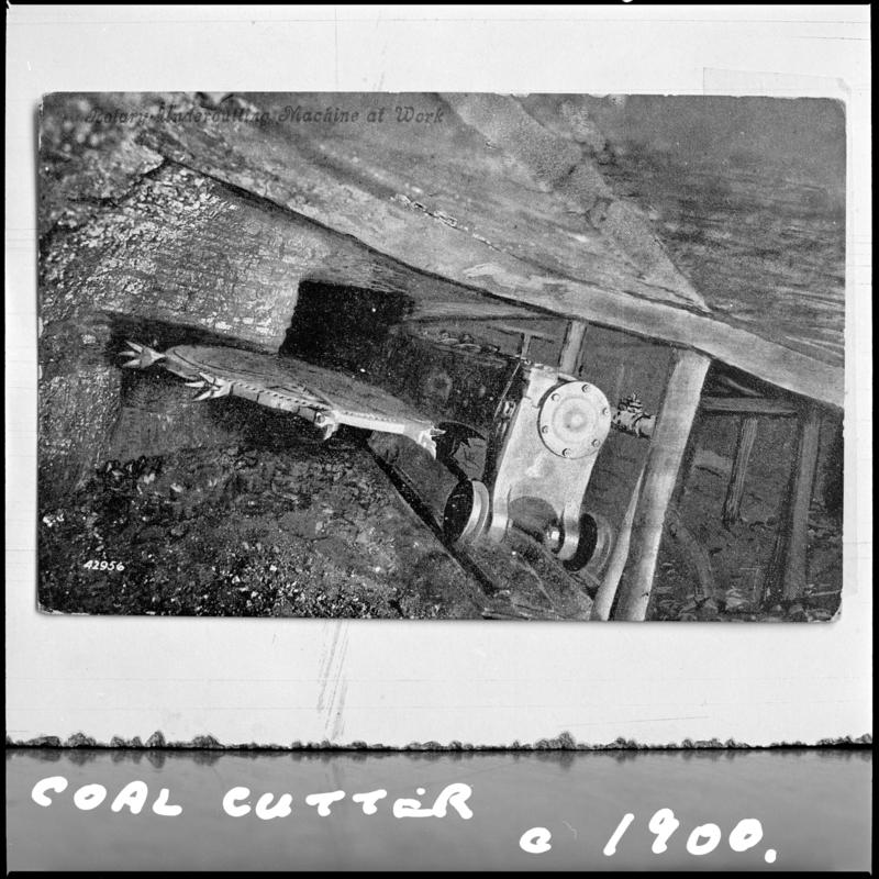 Black and white film negative of a photograph showing a coal cutter, unidentified colliery.  Image is photographed from a publication.  'Coal Cutter c.1900' is transcribed from original negative bag.