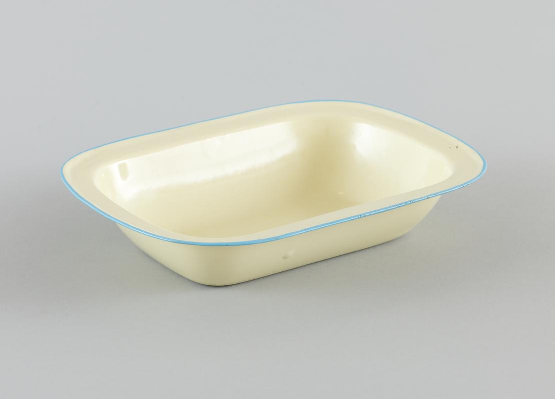 Pale yellow enamelware rectanuglar casserole dish, with a light blue rim.