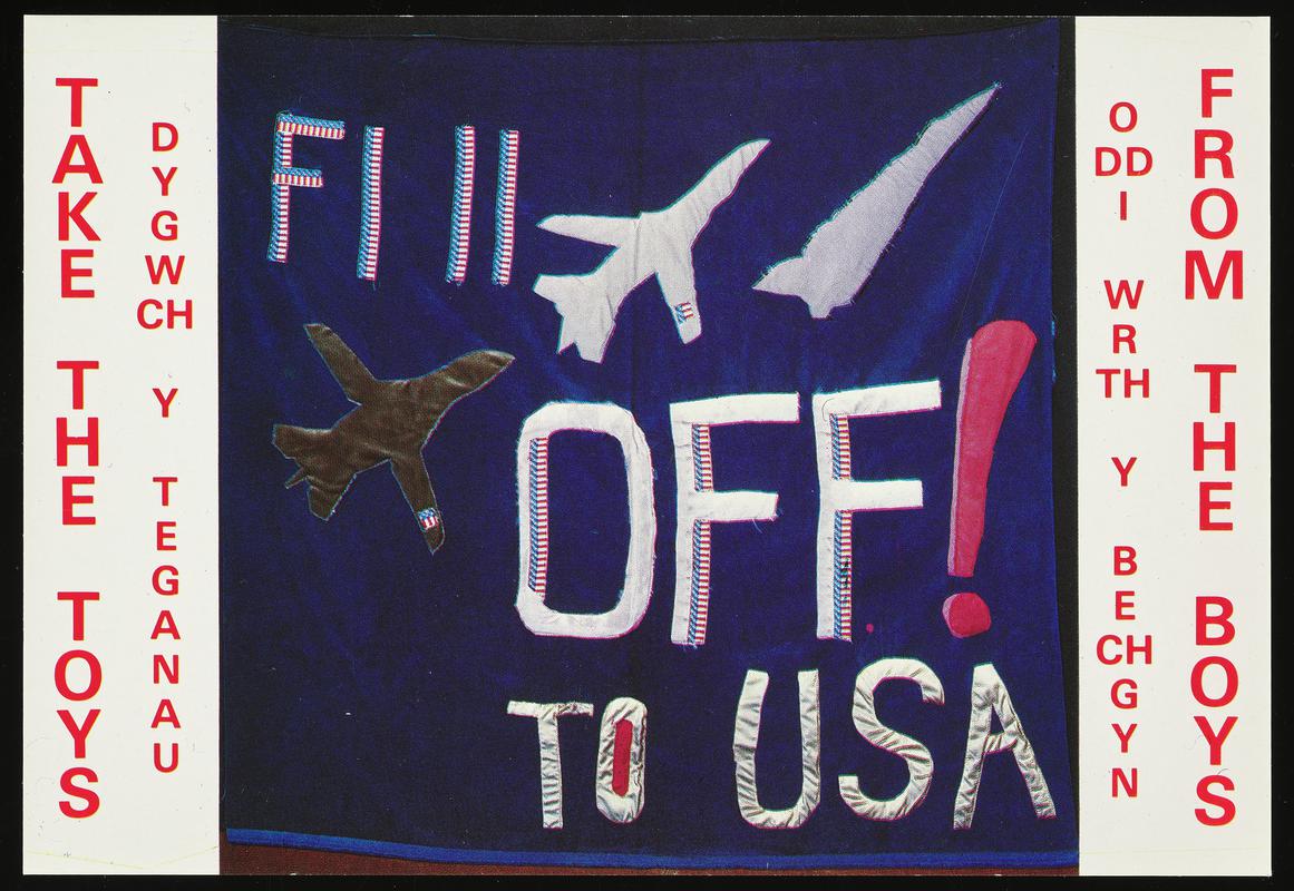 Colour postcard of a F1 11 Off! to USA banner. Original banner made by Thalia Campbell, Jan Higgs and Jan Campbell for the blockade of the U.S.A.F. Nuclear Strike Bomber Base at Upper Heyford on 31st December 1982.