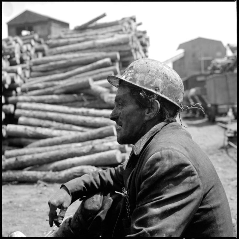 Black and white film negative showing a miner in the timber yard at the end of the morning shift, Big Pit 1978.