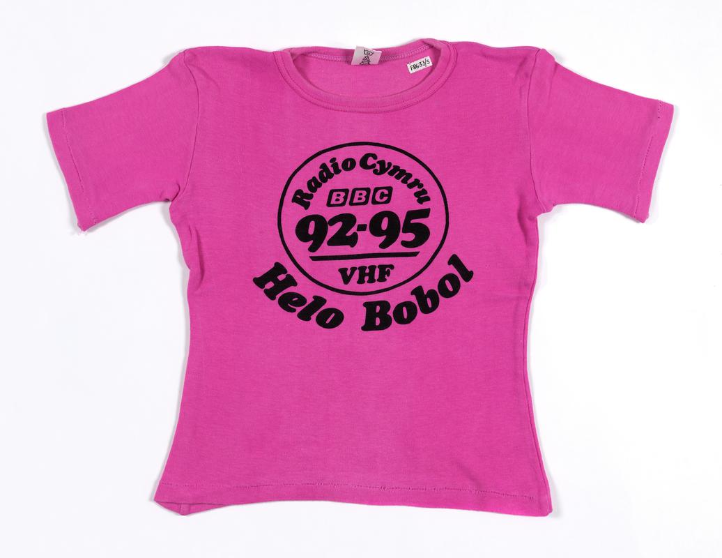 Shocking pink knitted cotton t-shirt promoting the BBC Radio Cymru programme 'Helo Bobol'.