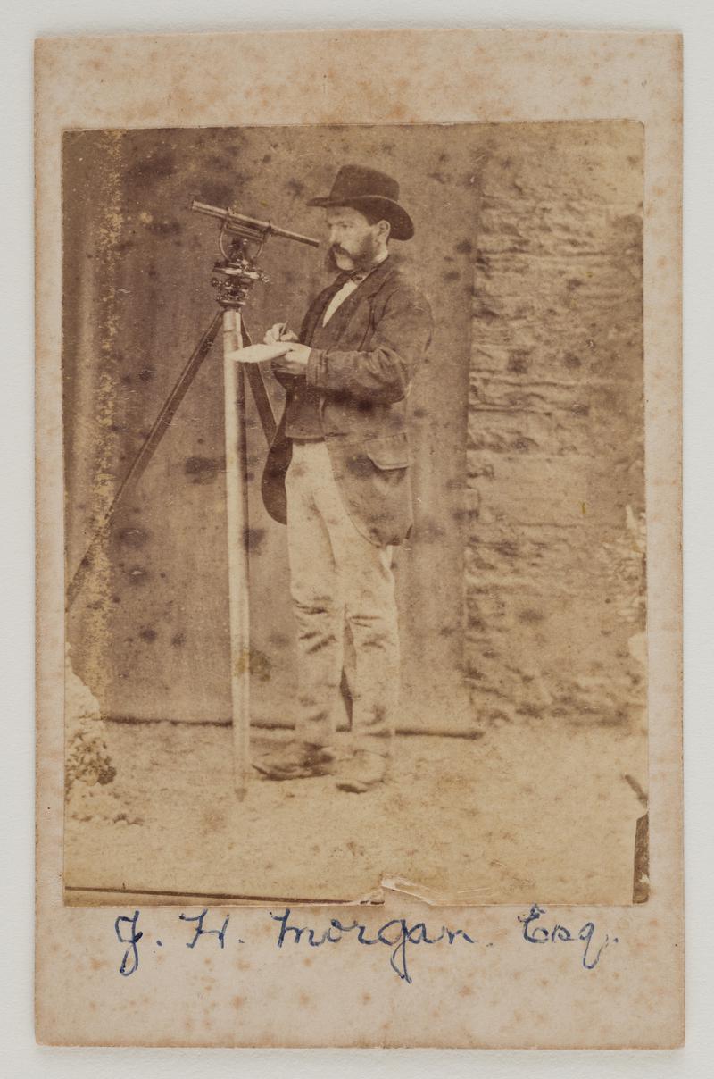 Photograph of J.H. Morgan using surveying equipment.