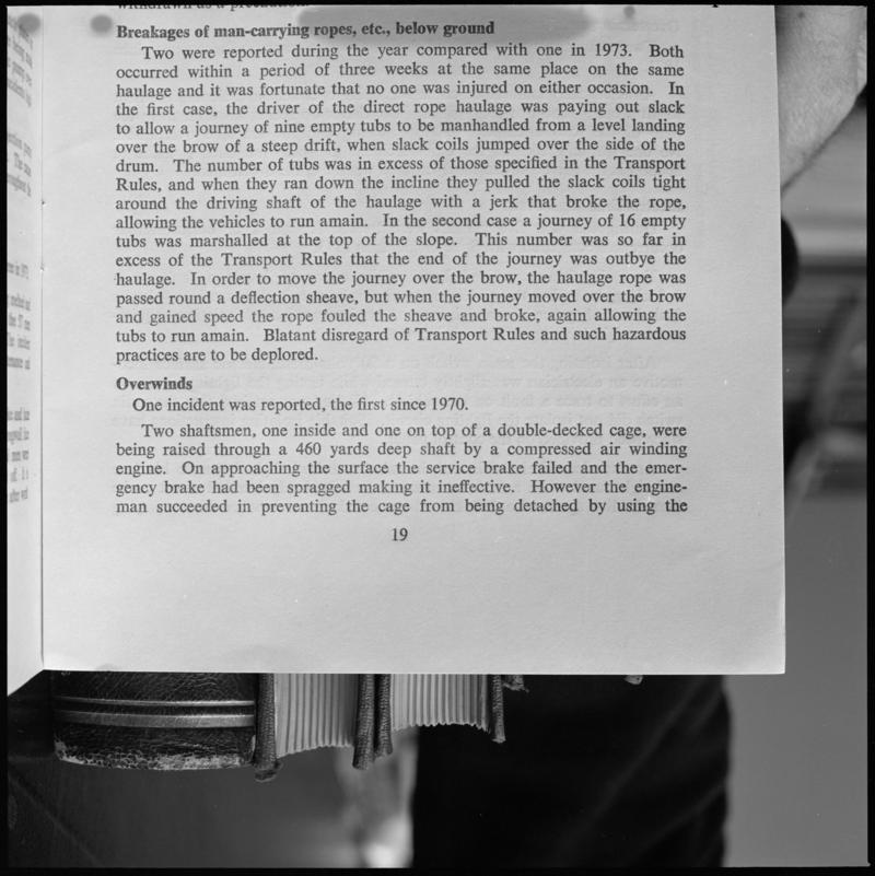 Black and white film negative showing text discussing the 'breakages of man-carrying ropes etc, below ground, photographed from a publication.