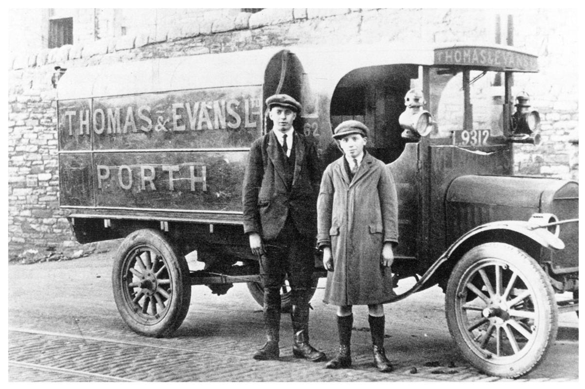 Two men standing in front of a Thomas & Evans Ltd. delivery van.