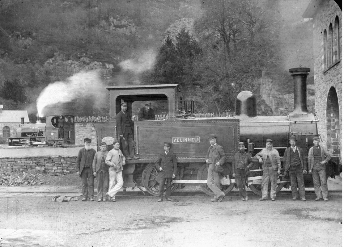 View of the steam locomotive 'Velinheli' outside the Gilfach Ddu workshops, with the narrow gauge steam locomotive 'Vaenol' (later re-named 'Jerry M') in the background