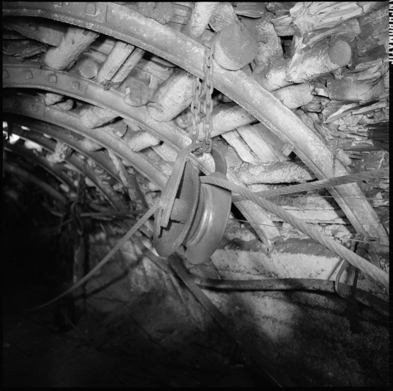 Black and white film negative showing a pulley and haulage rope, underground at Wyndham Western Colliery. 'Wyndham Western' is transcribed from original negative bag.