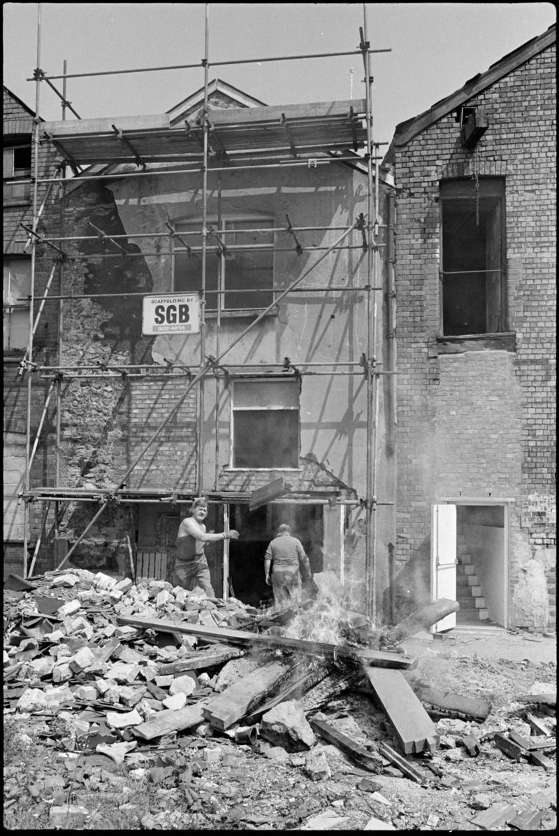 Workmen burning old timber outside 105 and 106 Bute Street. These premises were being renovated by Graham Bros. builders.