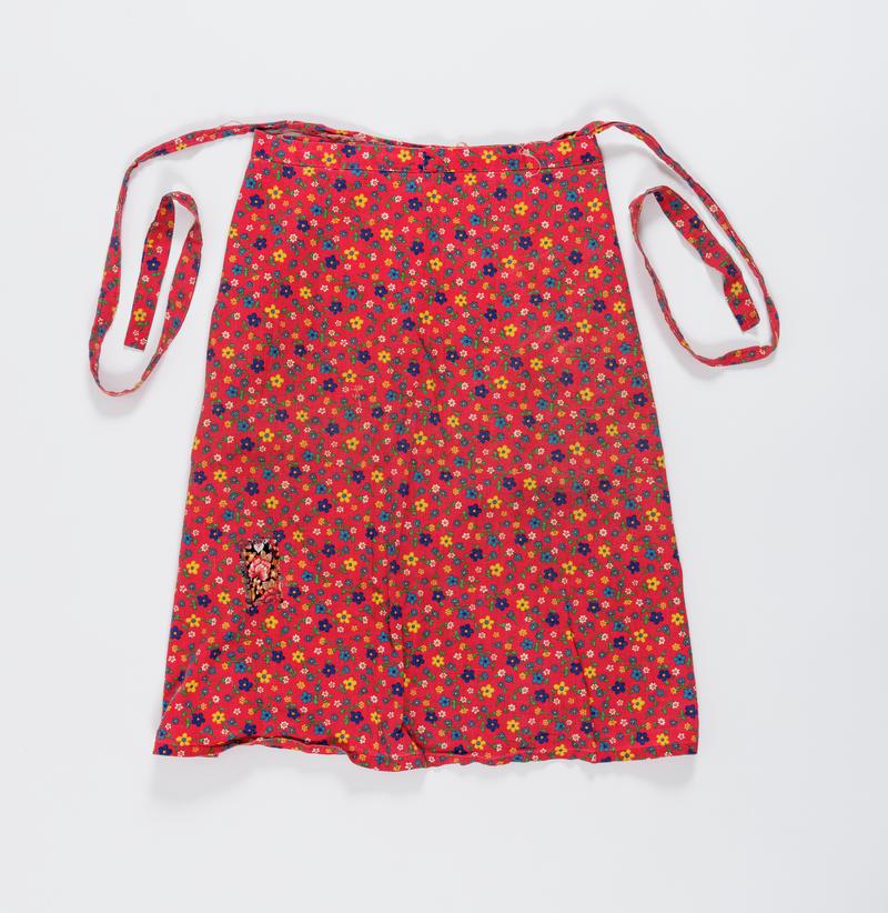 Red floral wrap around skirt worn by Thalia Campbell on the march from Cardiff to Greenham Common, 27 August - 5 September 1981.