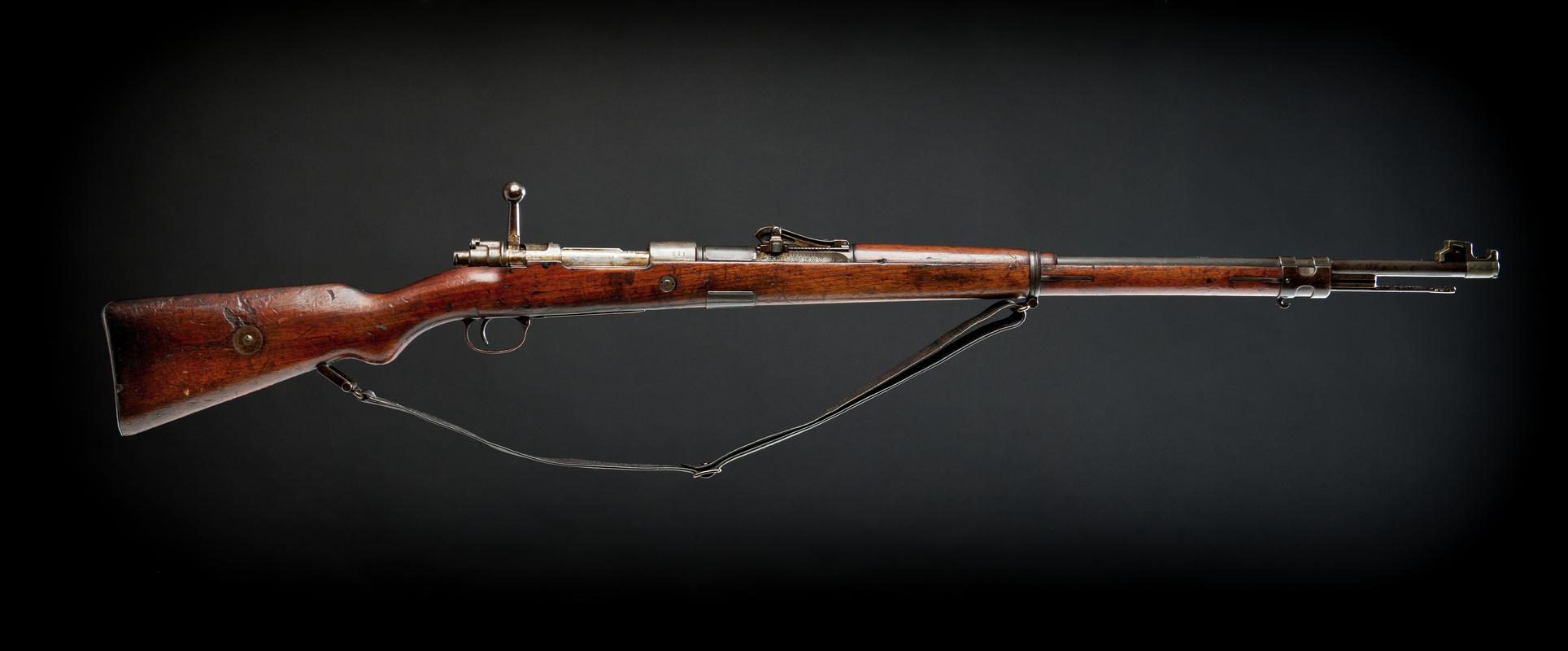 Amberg 5-shot bolt action rifle, with a leather carrying strap and cleaning rod. Fitted with sights on barrel.