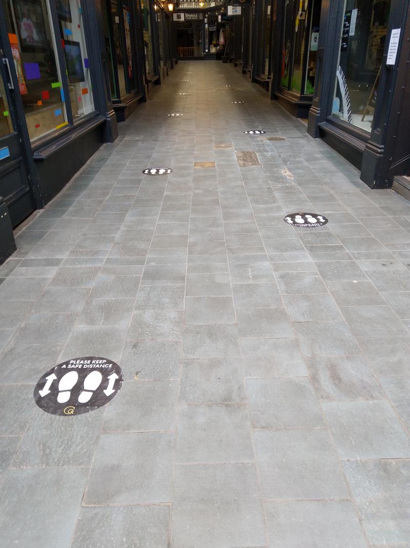 Social distancing signs on the floor of Castle Arcade, Cardiff.