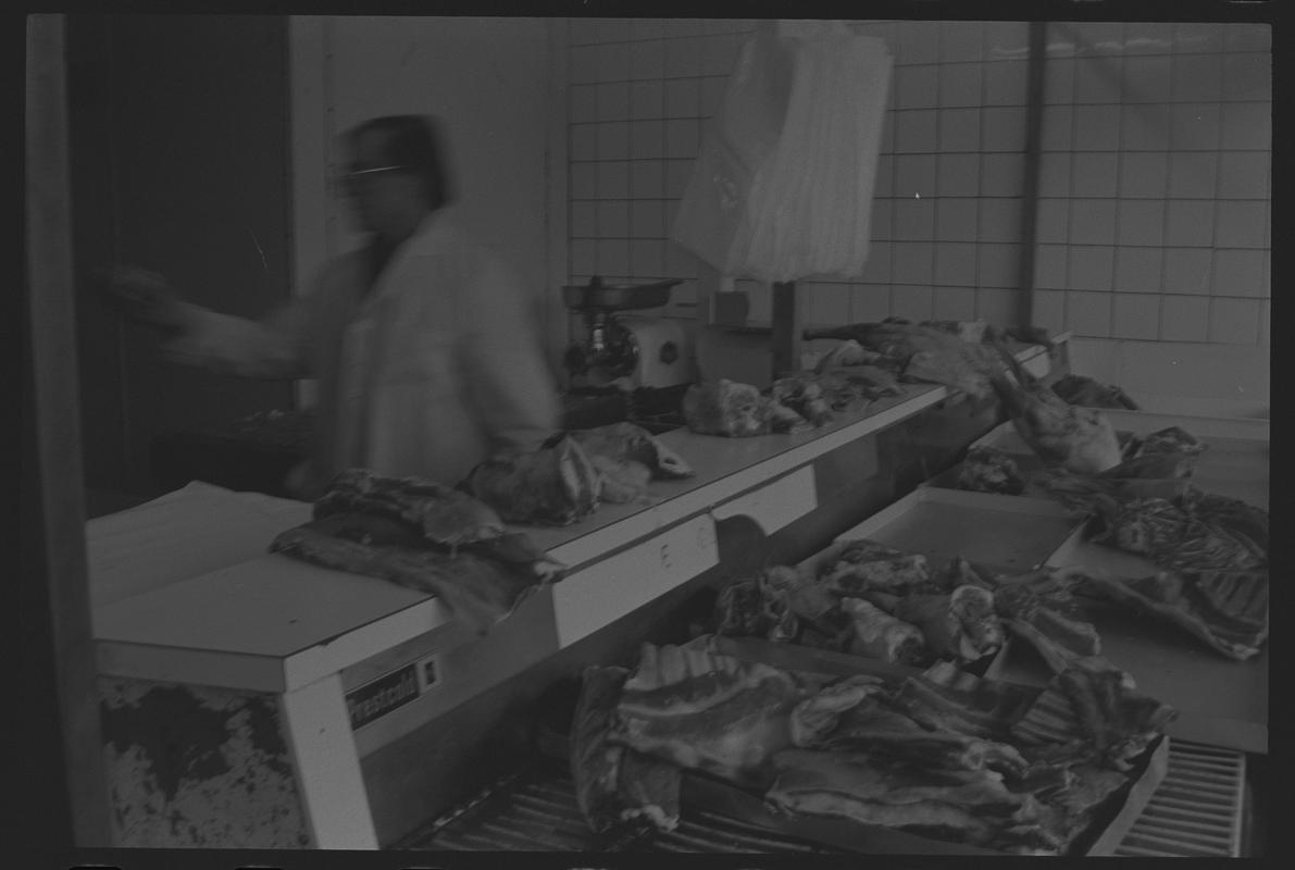 Butcher with meat ready for preparation in shop, Loudoun Square, Butetown.