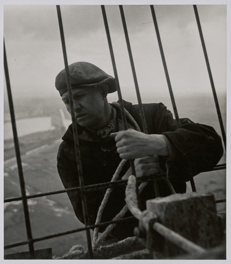 "Building the cooling tower" - Portrait of construction worker at the top of concrete cooling tower, Port Talbot. - Photographs of steelworks and South Wales [See also - NMW A 57568 ]