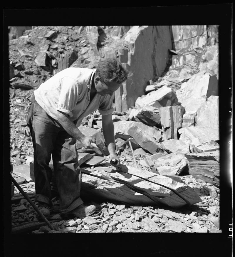 Quarryman preparing a large section of rock to be transported to the slate splitting and slate dressing sheds - 'bras hollti plyg',  Dinorwig Quarry, early 1960s.