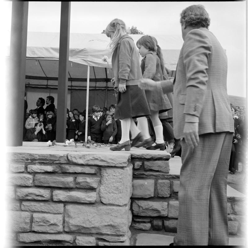 Black and white film negative showing the unveiling ceremony of the Senghenydd memorial, commemorating the 1913 Universal Colliery explosion.  The negative is undated but the ceremony took place in October 1981. 'Senghenydd' is transcribed from original negative bag.