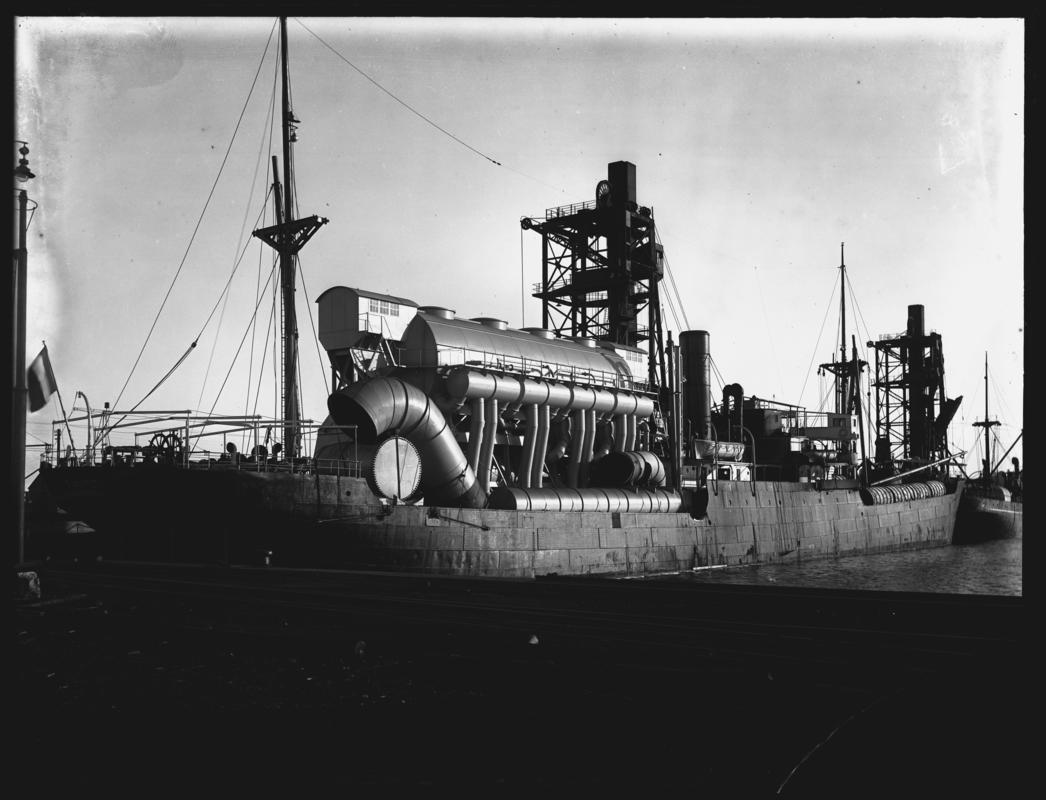 3/4 Starboard stern view of S.S. TUNISIE with machinery deck cargo, Cardiff Docks c.1933