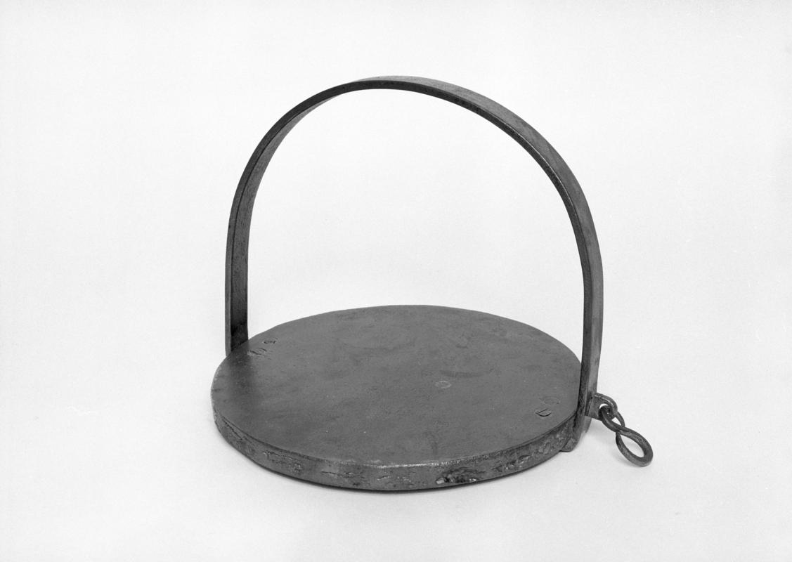 Bakestone, wrought iron circular plate with top handle welded to base and with an s-type hook on the side.