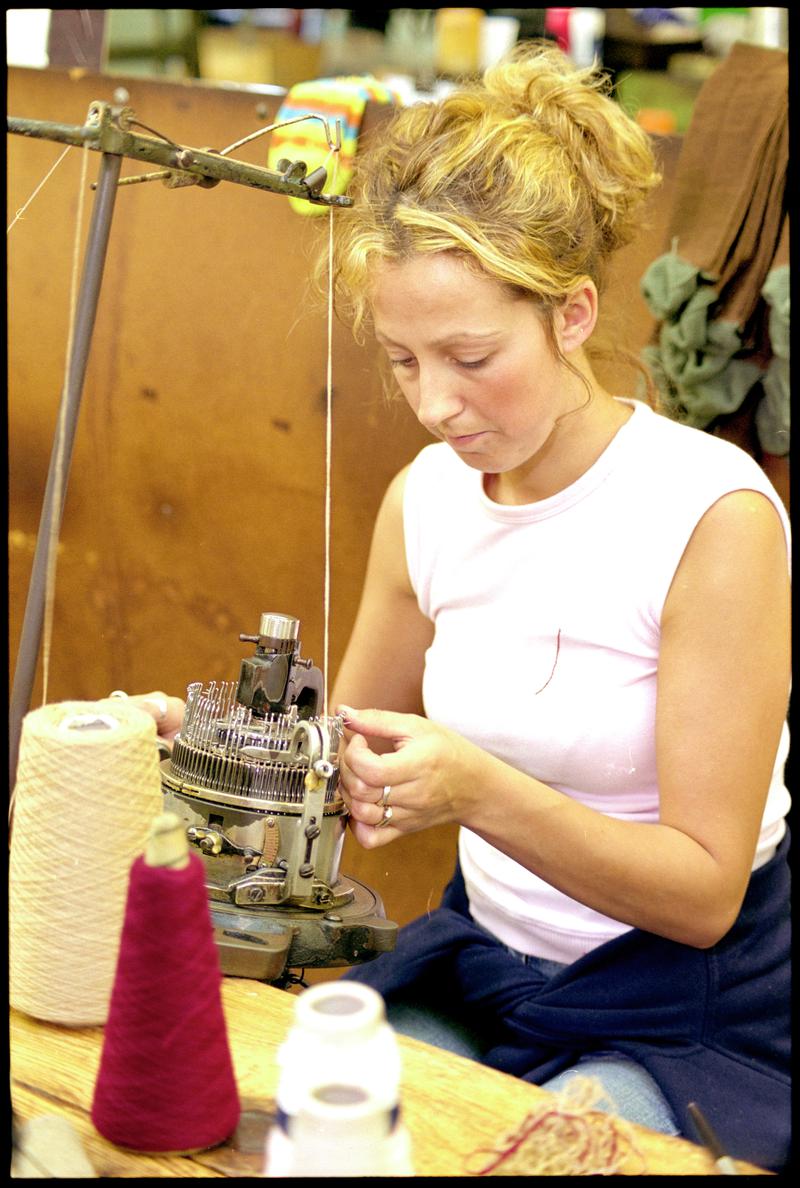 Donna Richards manipulating needles on a sock knitting machine to create cable patter. Corgi Hosiery Ltd factory, Ammanford, 1 July 2002.