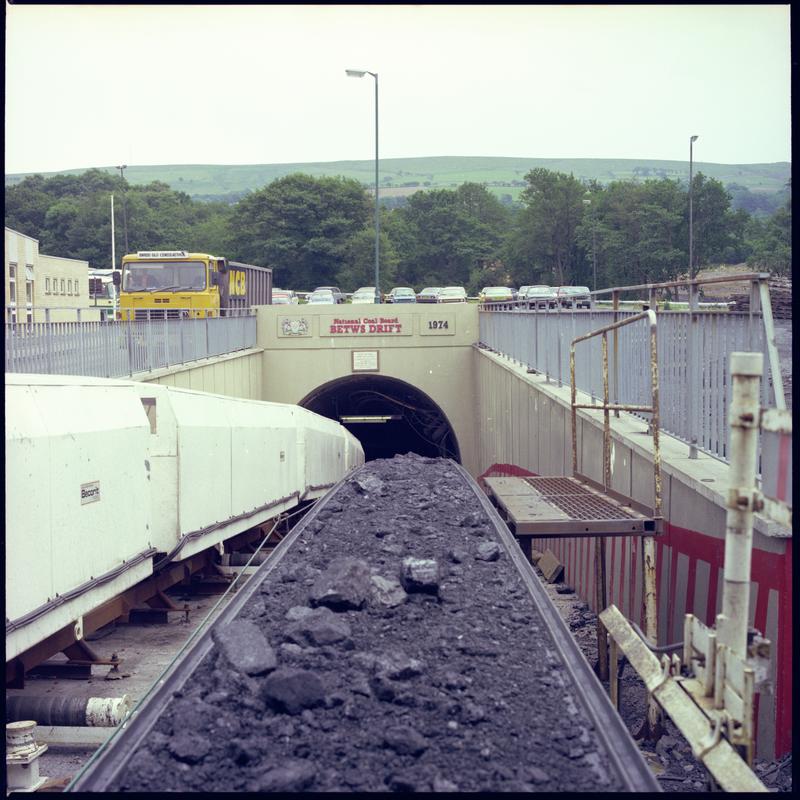 Colour film negative showing the entrance to the mine with man riding cars and conveyor, Betws Mine 10 June 1982.  '10 June 1982' is transcribed from original negative bag.
