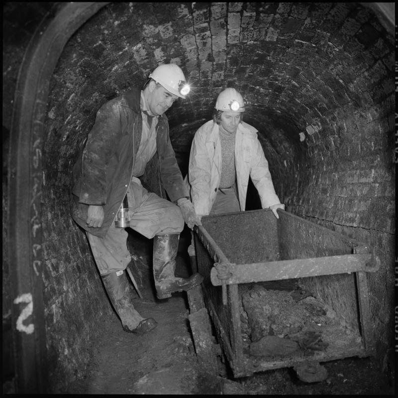 Black and white film negative showing two men pushing a dram, Big Pit Colliery.  'Big Pit Blaenavon' is transcribed from original negative bag.  Appears to be identical to 2009.3/2998.