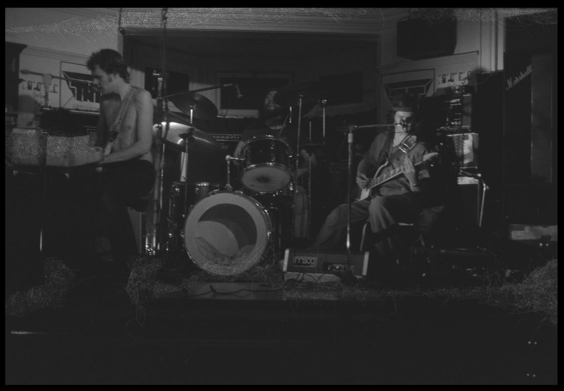 Guitarist and other members of TNT Group on stage. Location unknown.