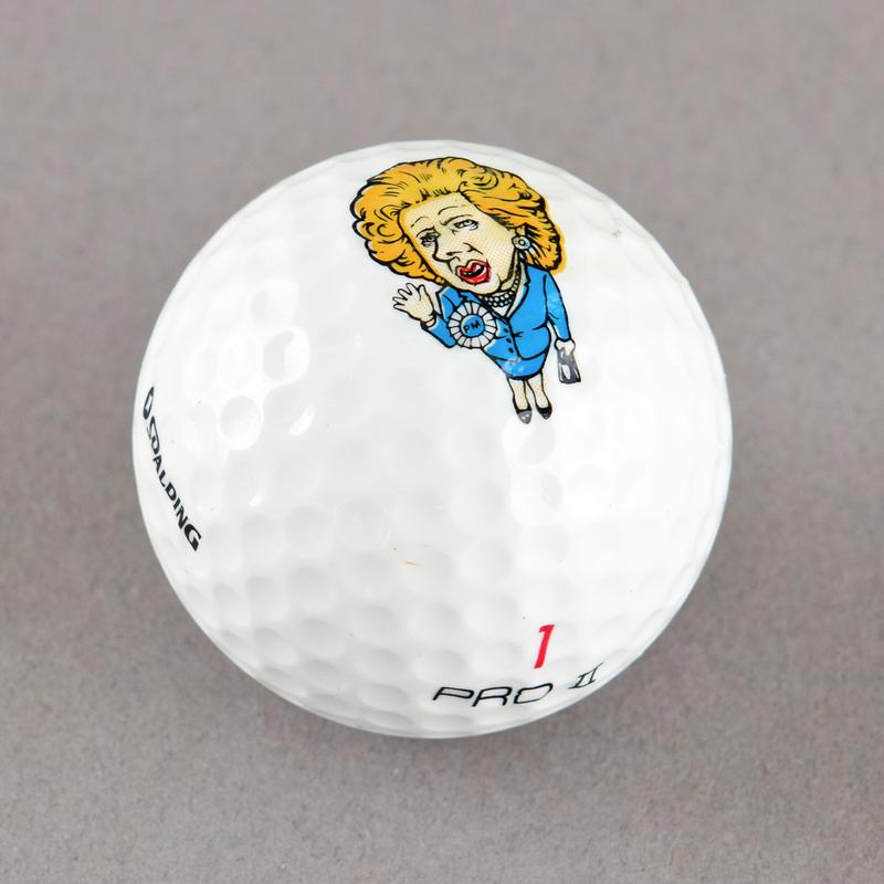 Golf ball with caricature of Margaret Thatcher. Sold during 1984-85 Miners' Strike.
