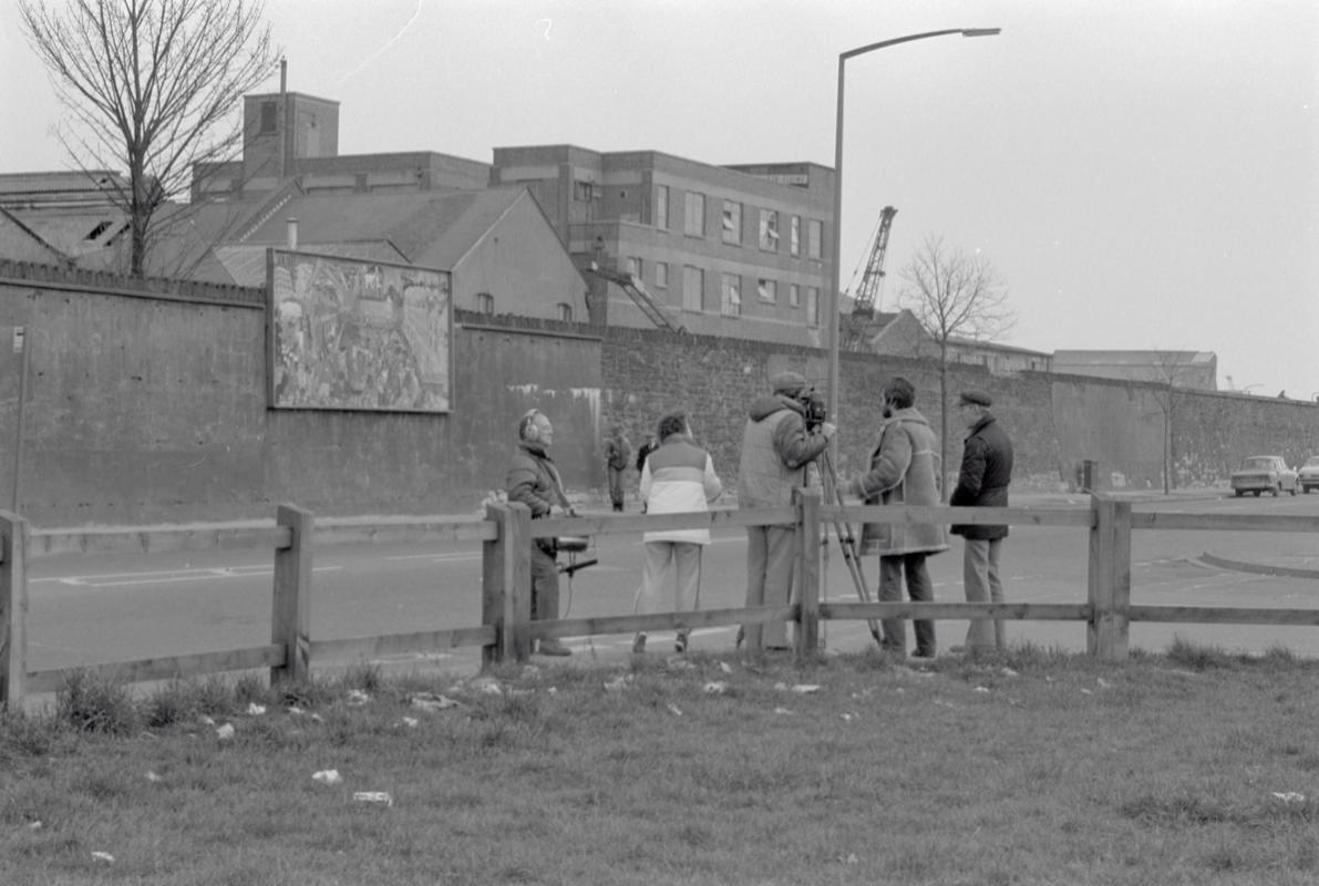 Film crew on Bute Street opposite mural on wall of railway embankment.