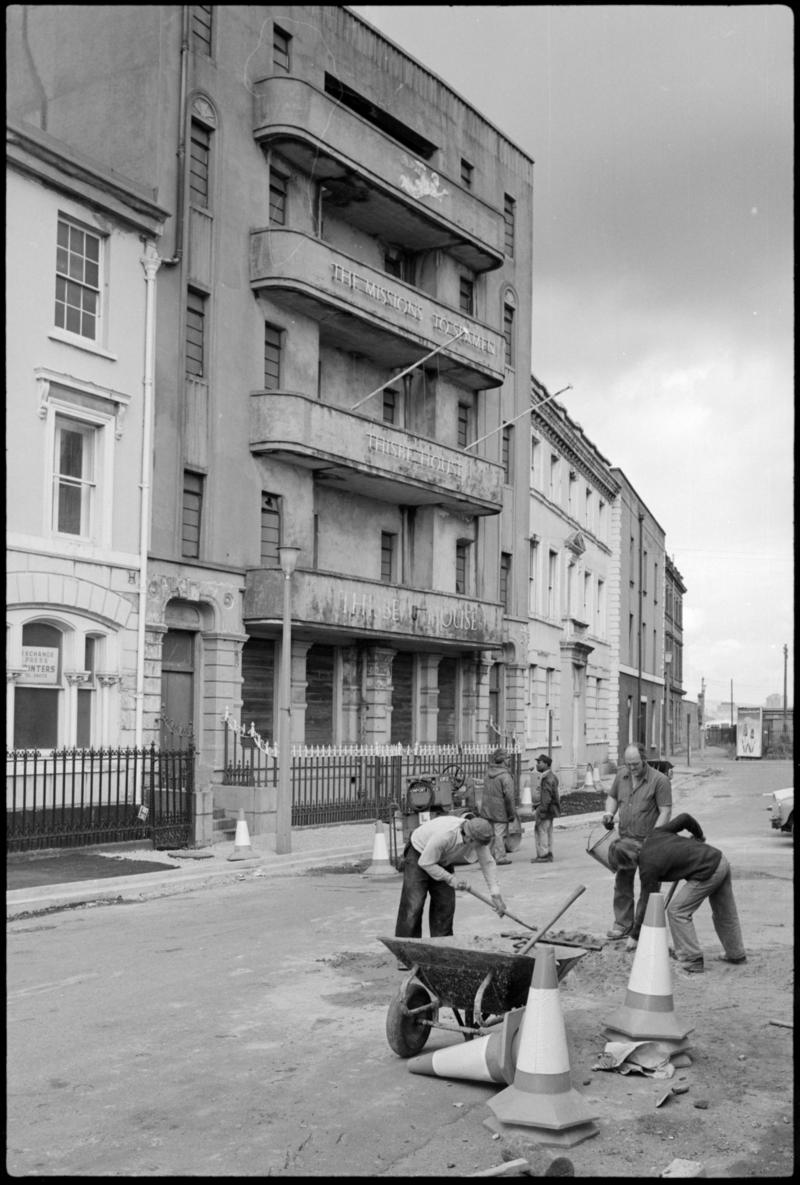Thisbe House, The Missions to Seamen, Bute Crescent, Cardiff Docks, with men repairing the road in foreground.