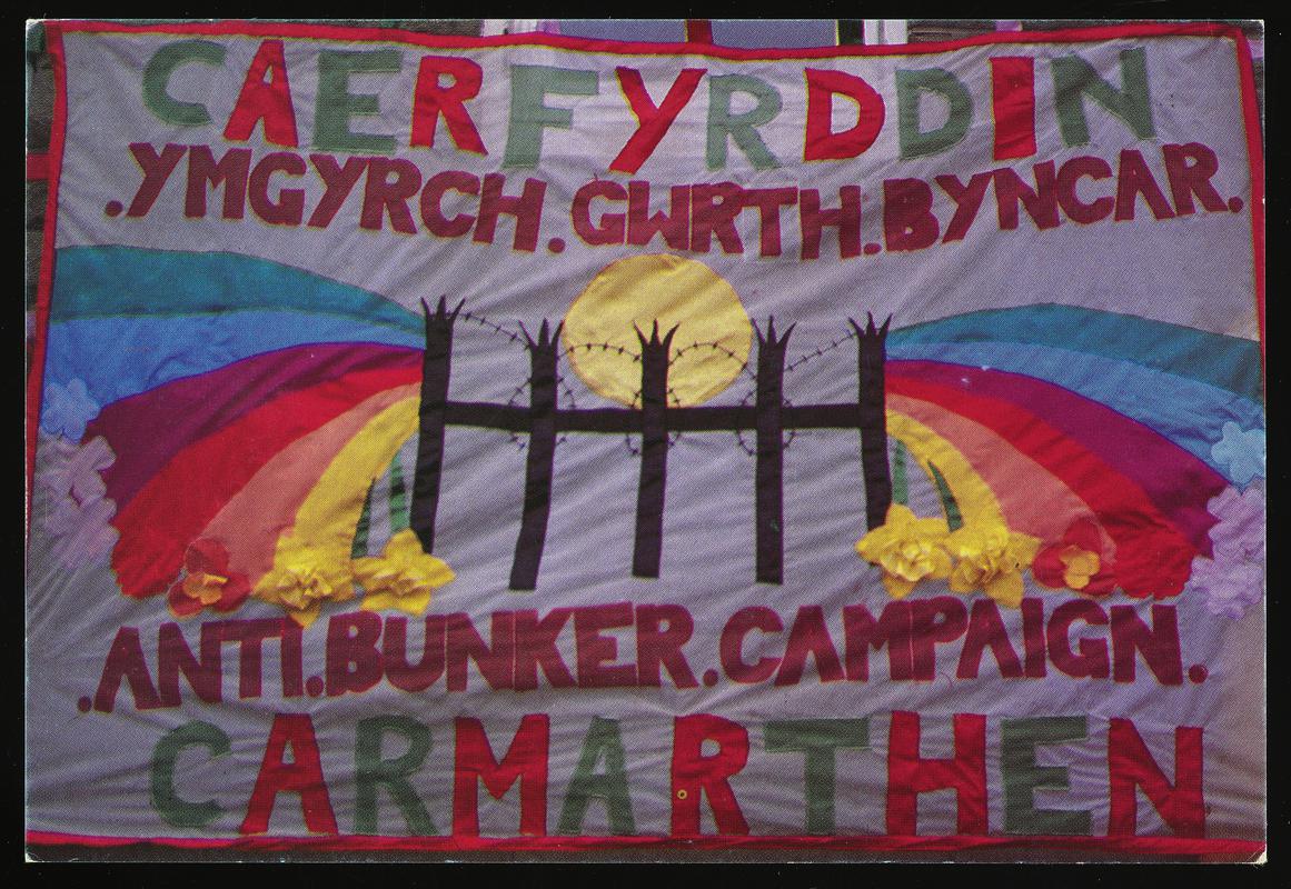 Colour postcard of a Caerfyrddin. Ymgyrch. Gwrth. Byuncar banner.