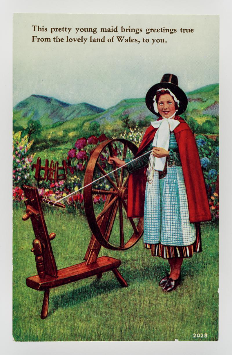 Welsh lady standing by spinning wheel.