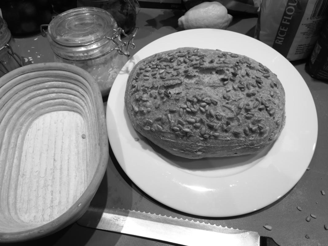 Finished sourdough bread with some of the stuff used in making and eating it.