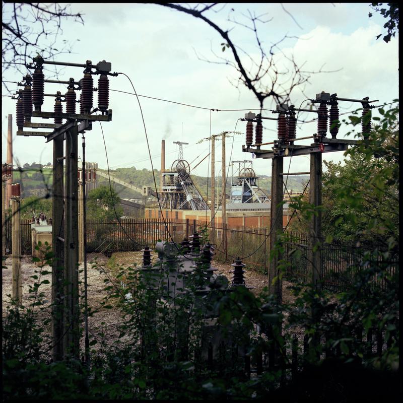 Colour film negative showing a view towards the upcast and downcast shafts, Nantgarw Colliery with electricity pylons in the foreground.  'Nantgarw' is transcribed from original negative bag.