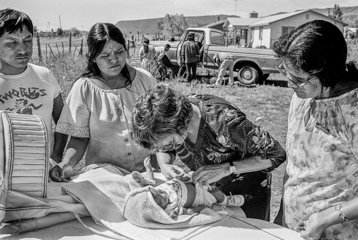 USA. ARIZONA. Apache reservation. Doctor from Phoenix hospital examining new born baby. 1980.