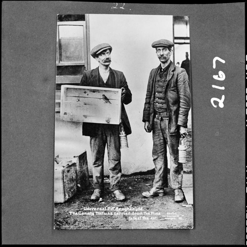 Black and white film negative showing two men, one of whom is carrying a canary in a cage, Universal Colliery, 1913.  'Sen 1913' is transcribed from original negative bag.