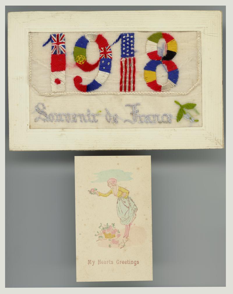 Embroidered postcard featuring the date 1918. With a small 'My Hearts Greetings' card inserted into a pocket on the front. Handwritten message on back.