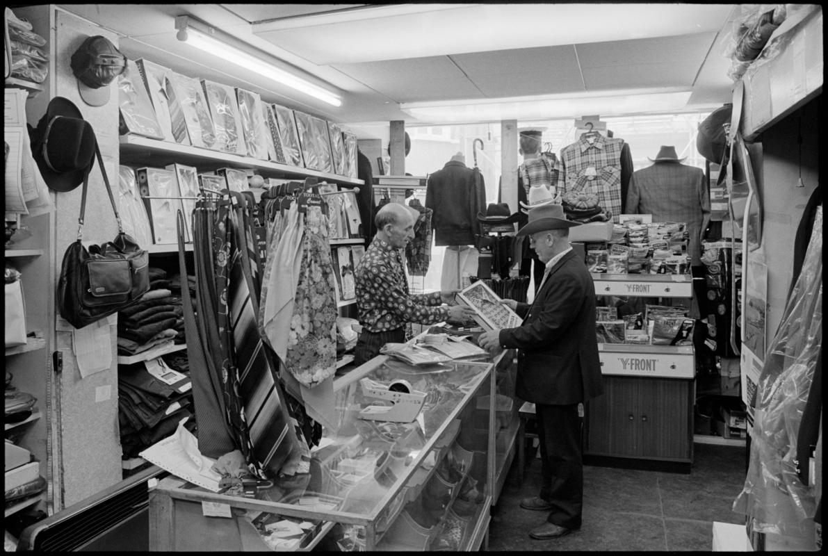 Interior view of 'Maurice Merchant Navy General Outfitter', 5 James Street, Butetown, showing the proprietor Mr M. Colpstein serving merchant seaman Mr T. Szarota. This was the last remaining outfitters in Cardiff Dockland.