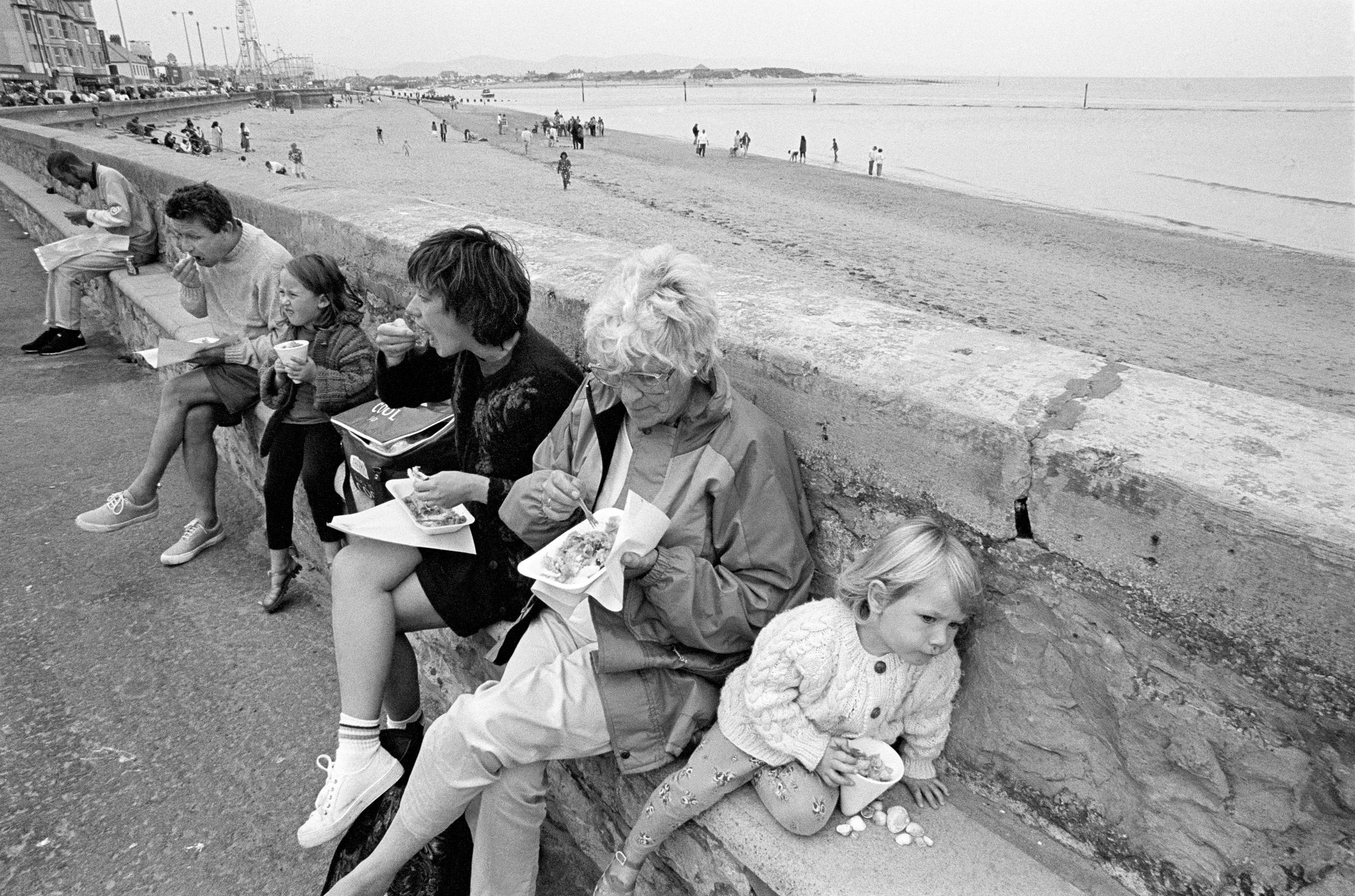 Family eating fast food, mainly fish and chips by the sea while on holiday. Rhyl, Wales