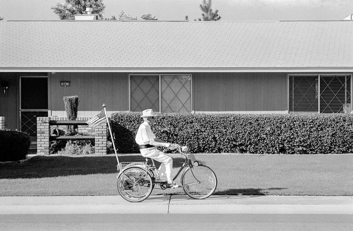 USA. ARIZONA. Sun City. A house holder goes for their afternoon strole. 1979.