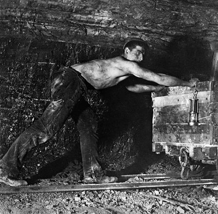 Worker pushing a cart in a mine