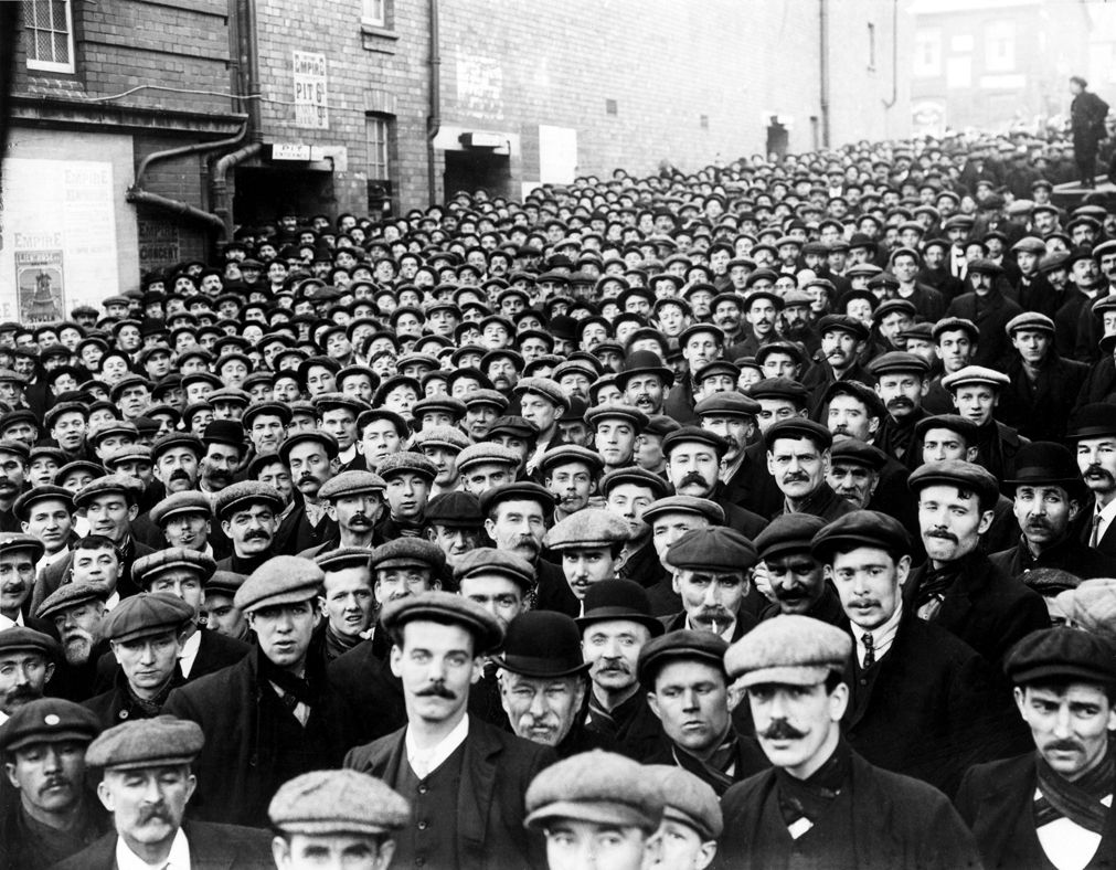 Miners waiting to go into the mass meeting at Empire theatre, Tonypandy on the 9th November 1910 (b/w photo)