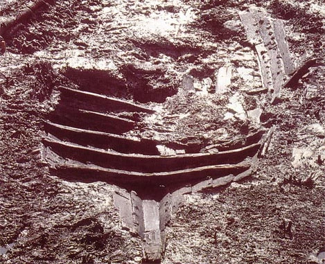 Gweddillion y cwch yn y mwd