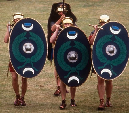 The Ermine Street Guard wedi gwisgo fel milwyr traed cynorthwyol. Byddai milwr traed cynorthwyol yng ngarsiwn Gelligaer wedi gwisgo crys llurig syml dros ben tiwnig, efallai gyda throwsus gwlân neu ledr, a helmed.