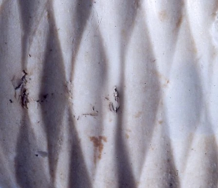 Manylyn o'r cerfwaith ar ben brysgyll Maesmor, sy'n dangos nam anghyffredin yn y cynllun, sef dau gwplws wedi'u torri (gweler canol y llun).