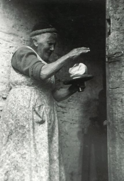 Dynes yn gafael mewn teclyn pren siâp madarch ac yn clapio menyn