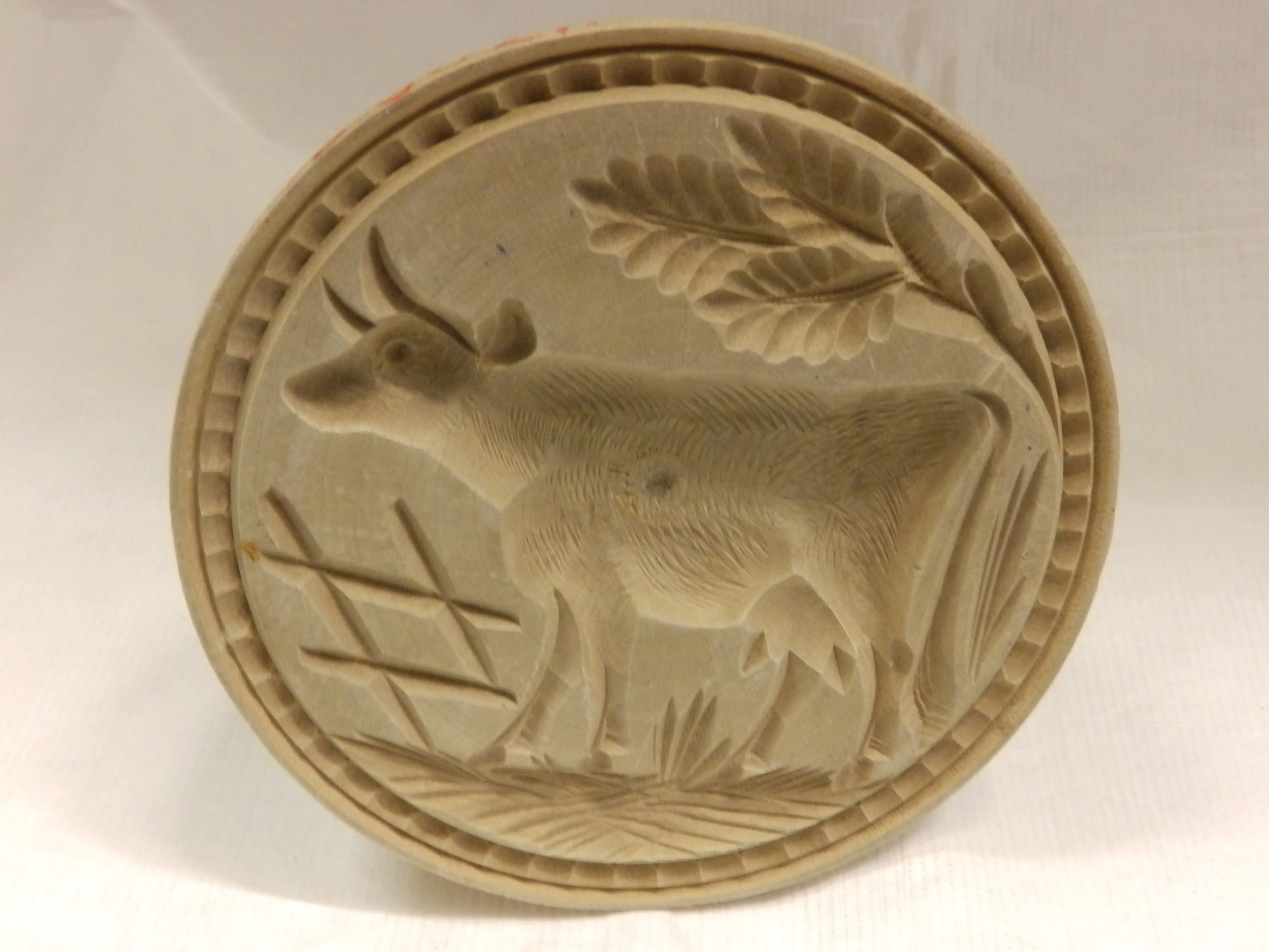 Print menyn gyda buwch wedi ei gerfio arno.