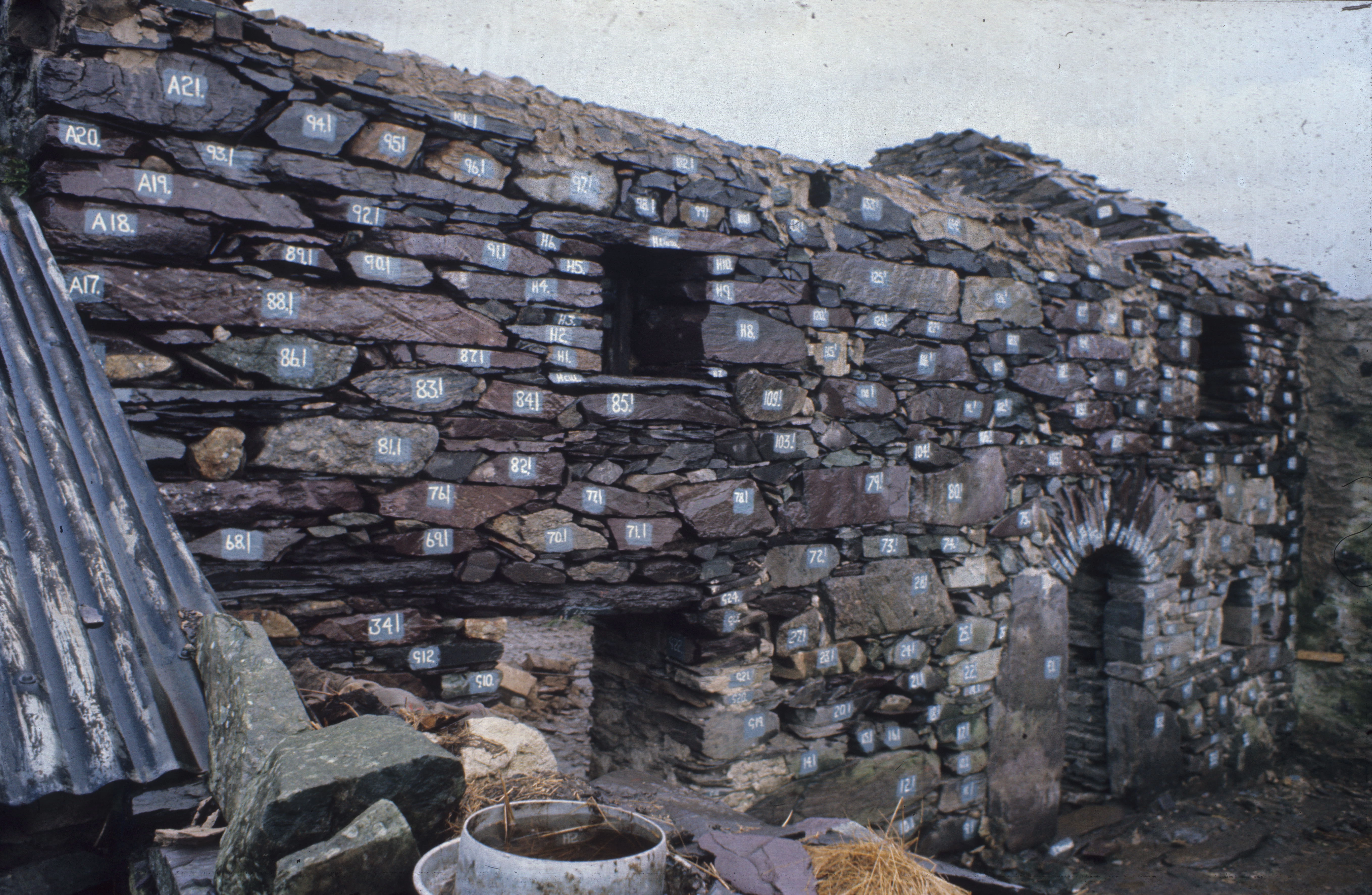 tu allan yr adeilad gyda'r cerrig wedi eu rhifo