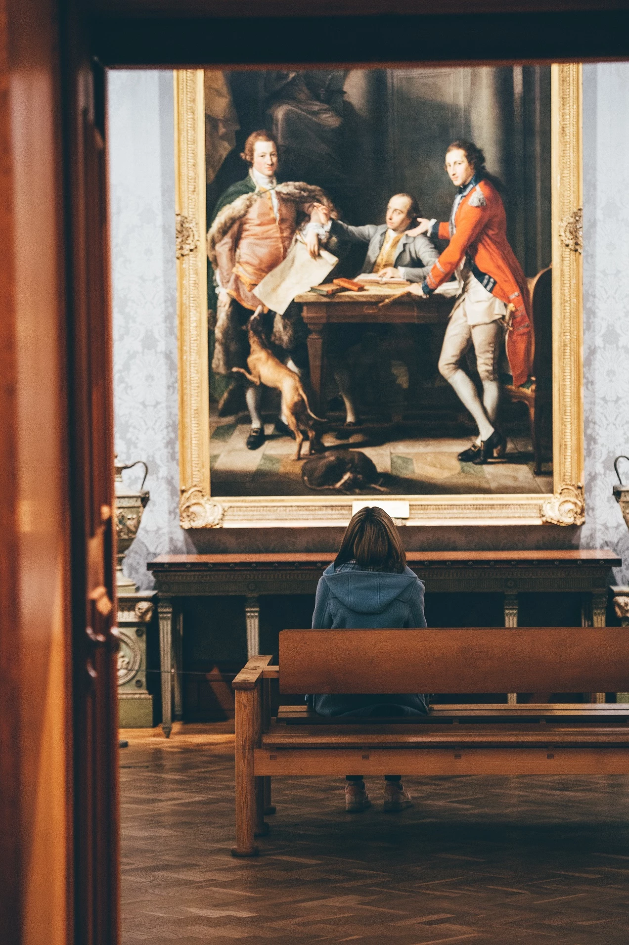 Llun o fenyw yn eistedd o flaen paentiad hanesyddol