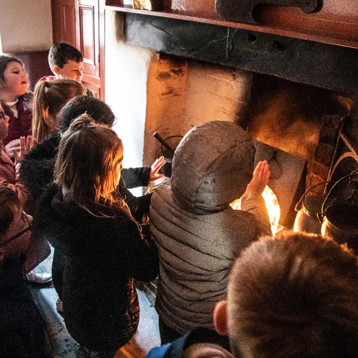 Plant yn sefyll o gwmpas lle tan yn y ty 1861.