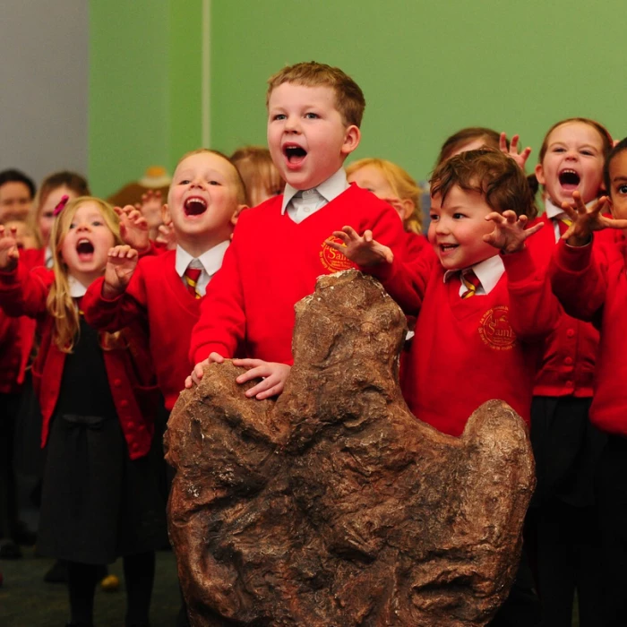 Llun o grŵp o blant yn rhuo fel deinosor