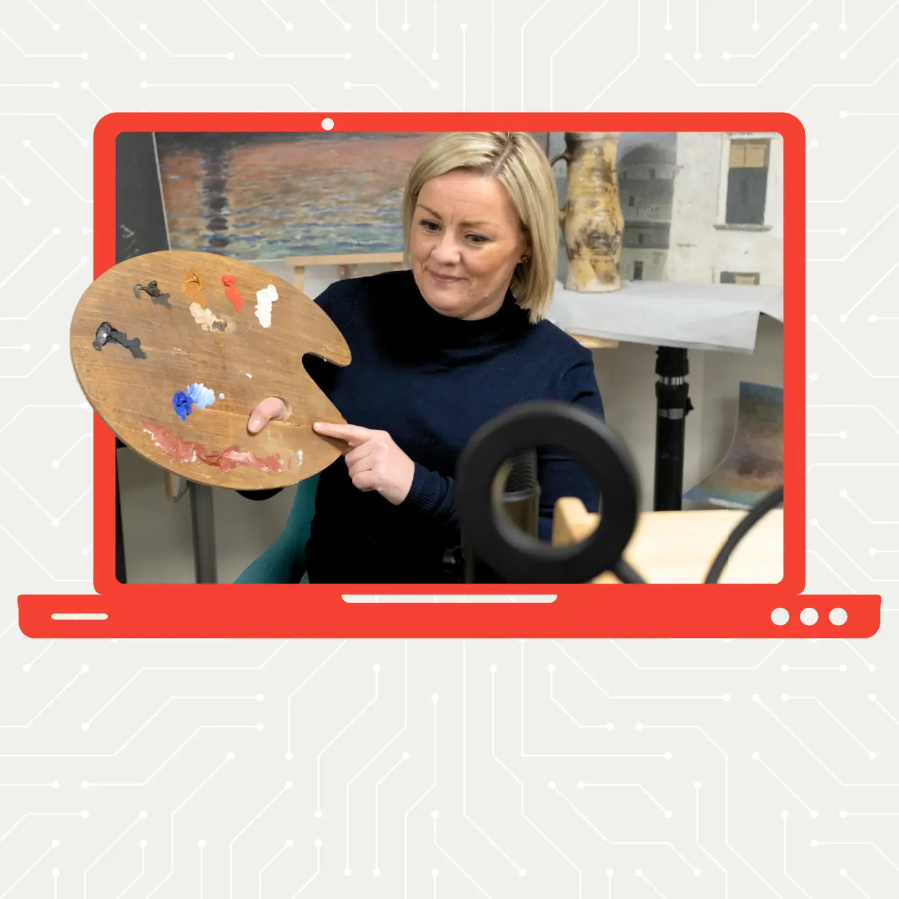 Menyw â gwallt melyn yn dal palet paent o flaen camera